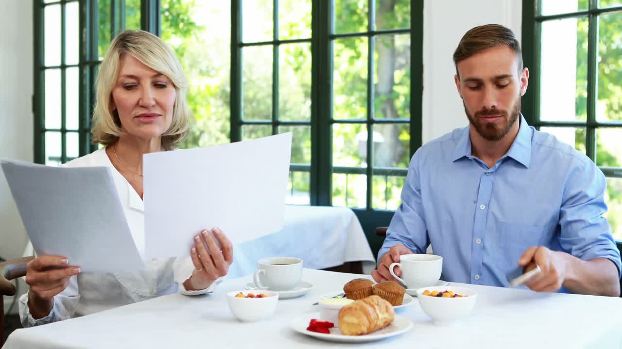 mujer ejecutiva mirando un documento mientras su colega habla por teléfono móvil 4k