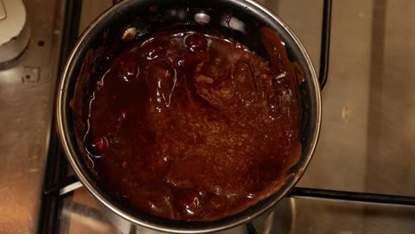 Melted-hot-milk-chocolate-with-hazelnuts-and-bubbles-on-the-gas-stove-in-a-small-pot