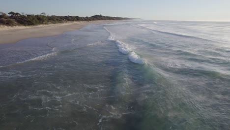 Schaumige-Wellen-Kommen-Bei-Sonnenaufgang-An-Der-Sandigen-Küste-Von-Coolum-Beach-In-Queensland,-Australien