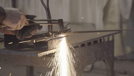 Metal-worker-cutting-a-piece-of-steel-with-handheld-plasma-cutter