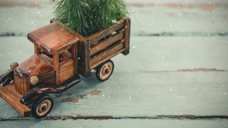 model car with a christmas tree on its load are combined with falling snow