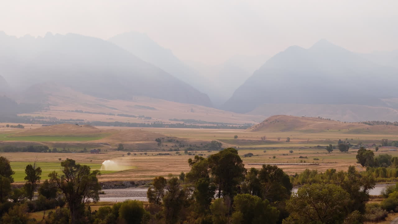 Paesaggio di valle montana con campi coltivati e fiume