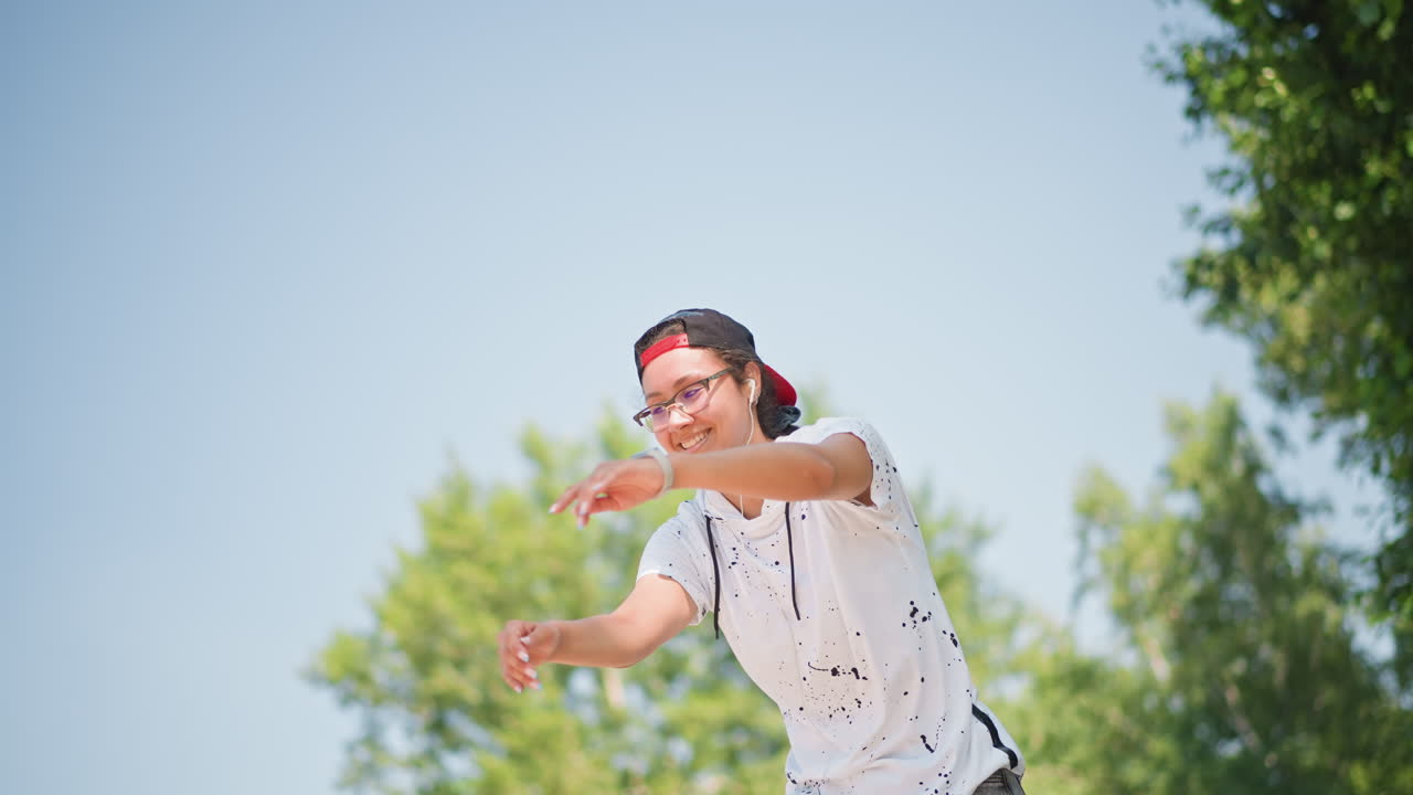 팔을 뻗어 밝은 하늘을 향해 뻗는 야외 무용수, 공원 나무와 멀리 보이는 스카이라인, 유연한 움직임과 제어된 균형, 표현력 있는 공연으로 바뀌는 집중적인 리허설, 집중