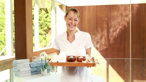 smiling masseuse holding a tray