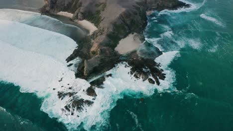 Waves-crashing-on-natural-peninsula-of-Tanjung-Bongo-in-Lombok,-aerial