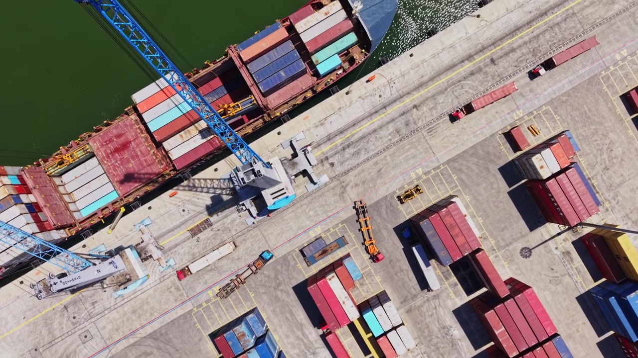 Large cargo ship being loaded with containers at busy shipping dock