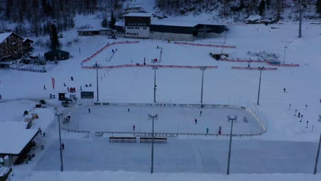 antena de gente jugando al hockey sobre hielo en la pista de hockey en un paisaje cubierto de nieve