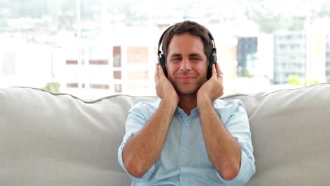 hombre relajándose en el sofá escuchando música