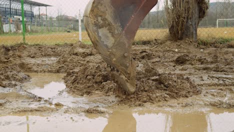 excavadora industrial del sitio de construcción recoge lodo de las inundaciones de carreteras