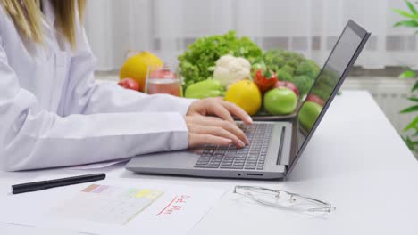 Working-with-laptop,-dietitian-prepares-researches-and-plans-for-healthy-living.