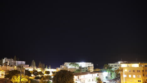 Dark-Starry-Night-Timelapse-Over-Bright-Beach-Town-In-Australia,-4K