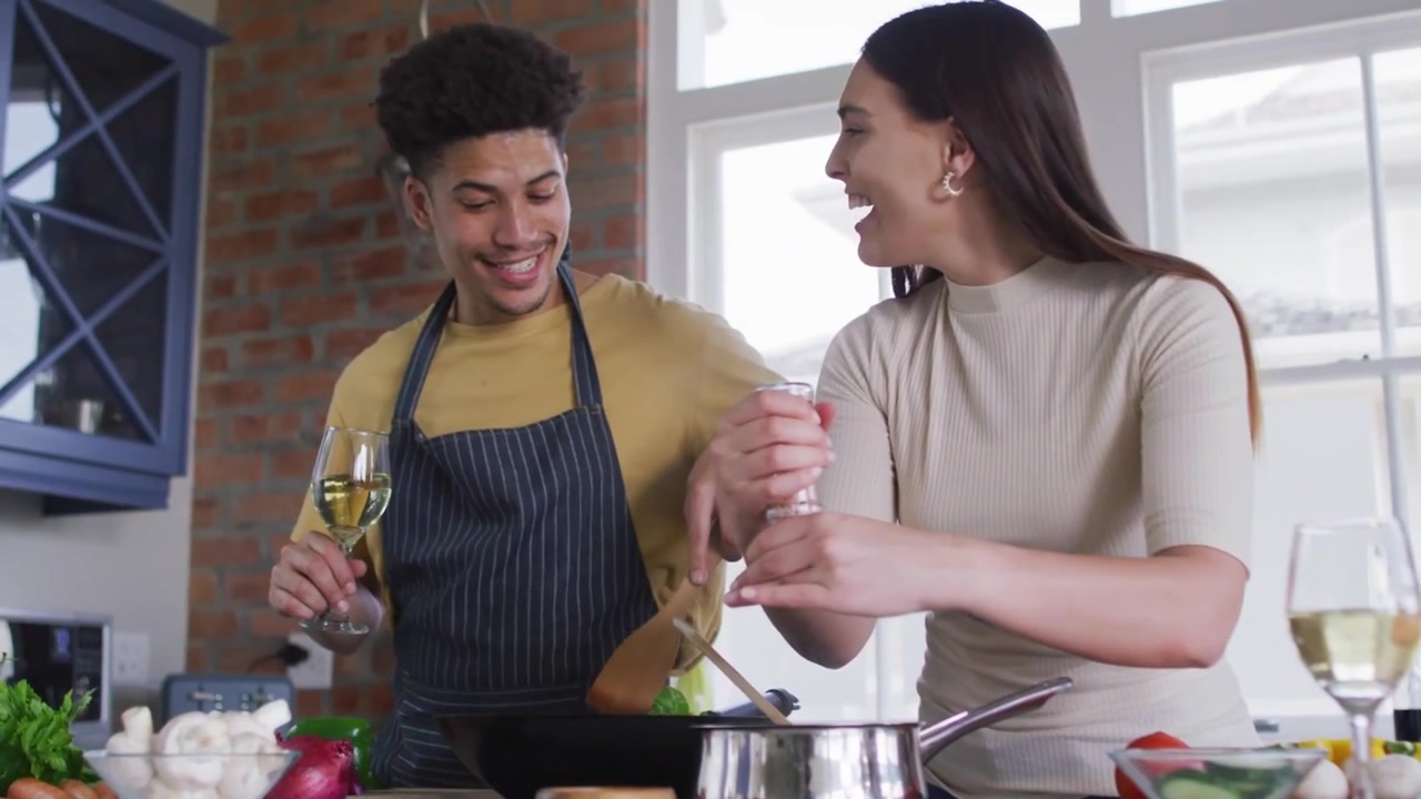 Video verticale: Coppia che cucina con correzione di glitch, donna che macina il pepe, uomo che sorseggia vino, mentre preparano la cena.