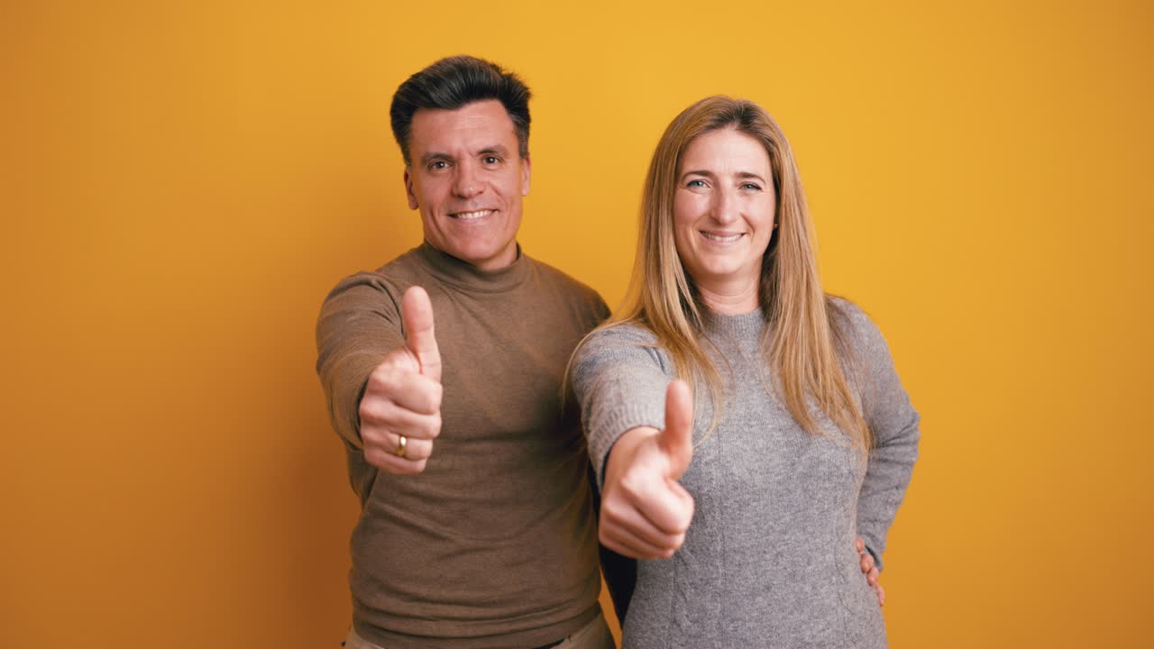 Uomo e donna felici che sorridono e fanno il pollice in su