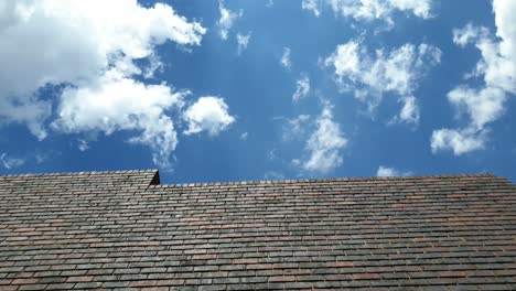 short but very smooth beautiful time lapse of clouds moving over a brick wall with sun rays beaming through on a summers day