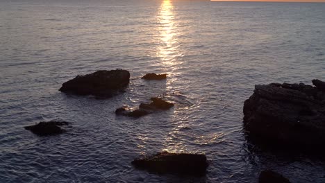 Inclinación-Cinemática-Lenta-Hacia-Arriba-Sobre-Rocas-En-El-Océano-Durante-El-Amanecer