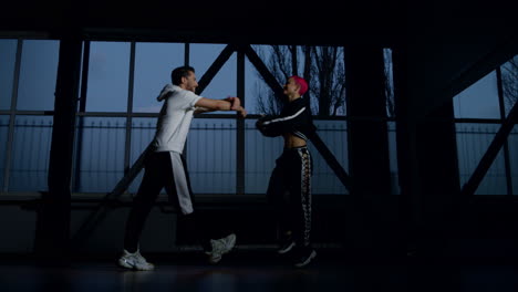 sporty couple dancing hip hop indoors. funky dancers exercising moves in studio.