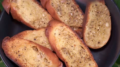 sliced garlic bread in a black pan or plate