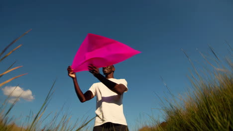 man playing with pink fabric outdoors under blue sky