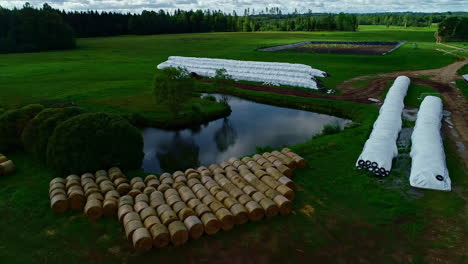 aerial view of many packed silos on an extensive organic green farm with a pond