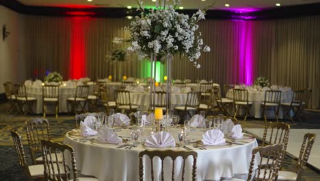 Mesa-Redonda-Decorada-Para-Bodas,-Centro-De-Mesa-Alto-Con-Flores-Paniculadas-De-Gypsophila,-Rosas-Blancas-Y-Follaje-Verde