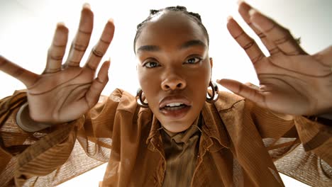 model reaching towards camera in slow motion on white background