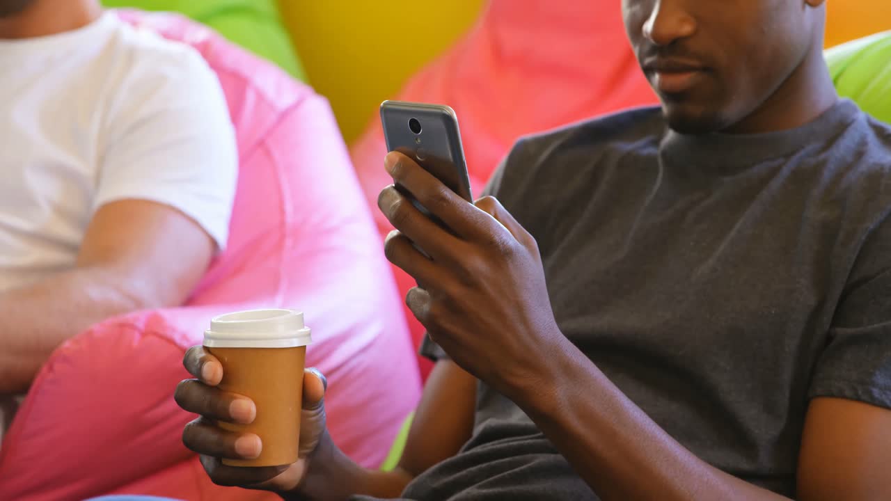 Black male executive using mobile phone in modem office 4k