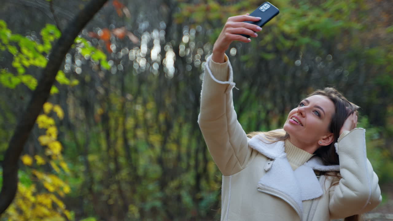 Mulher tirando uma selfie em um parque de outono