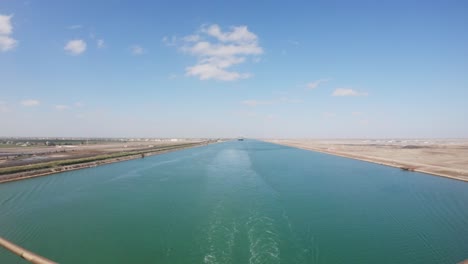 timelapse of a vessel sailing through suez canal on a sunny day in the desert