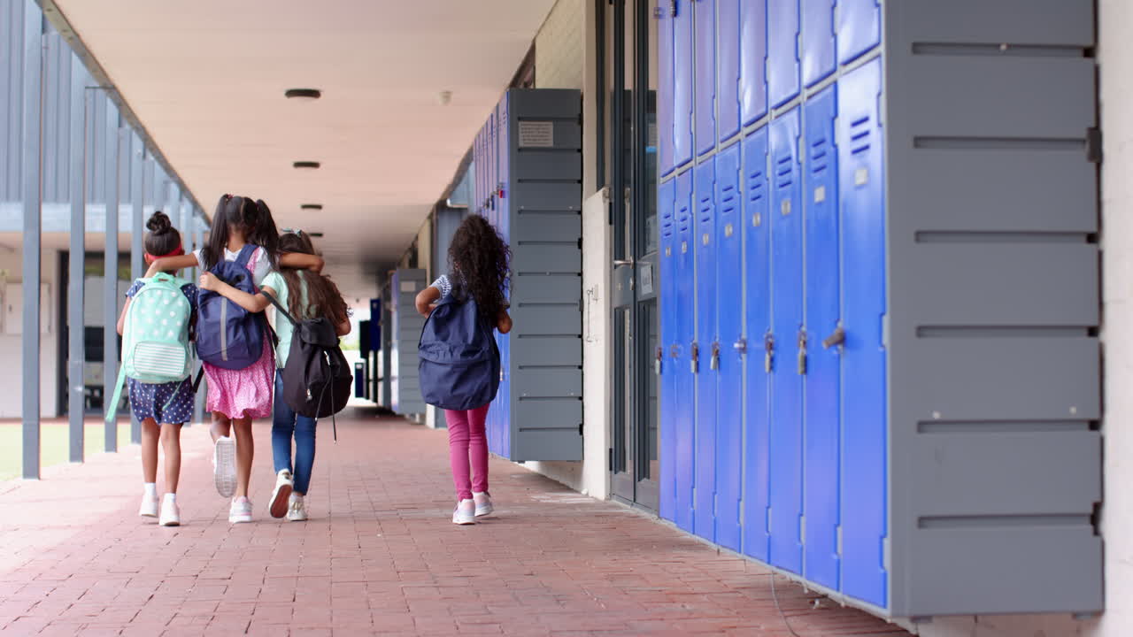 Walking in school hallway, group of students with backpacks heading to class