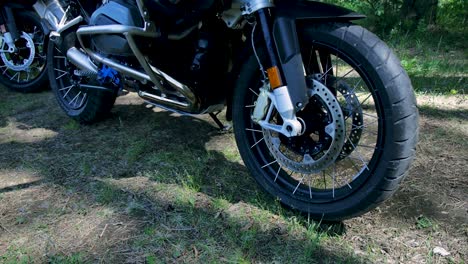 close-up of bmw adventure motorcycle wheels in a forest