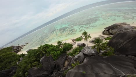 Fpv-drone-flying-on-a-Anse-Source-d'Argent-beach-in-Seychelles-on-an-Island-Mahe,-video-of-incredible-trees,-Seychelles-rocks,-seaside,-and-surrounding-Seychelles-landscapes