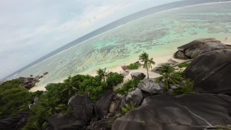 fpv drone flying on a anse source d'argent beach in seychelles on an island mahe, video of incredible trees, seychelles rocks, seaside, and surrounding seychelles landscapes