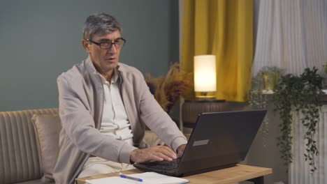 satisfecho con lo que ve en la computadora portátil, el anciano asiente con la cabeza.