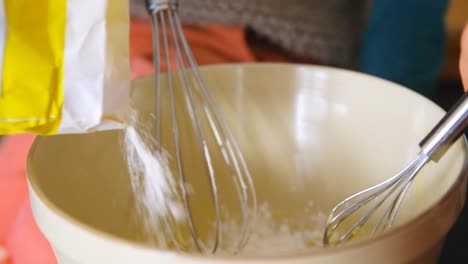 father and children pouring and stirring flour 4k