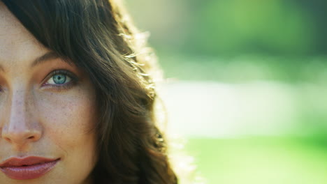 a young woman's face in a public park outside