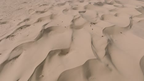 toma de drones de motociclistas todoterreno en dunas de arena en glamis, desierto de california