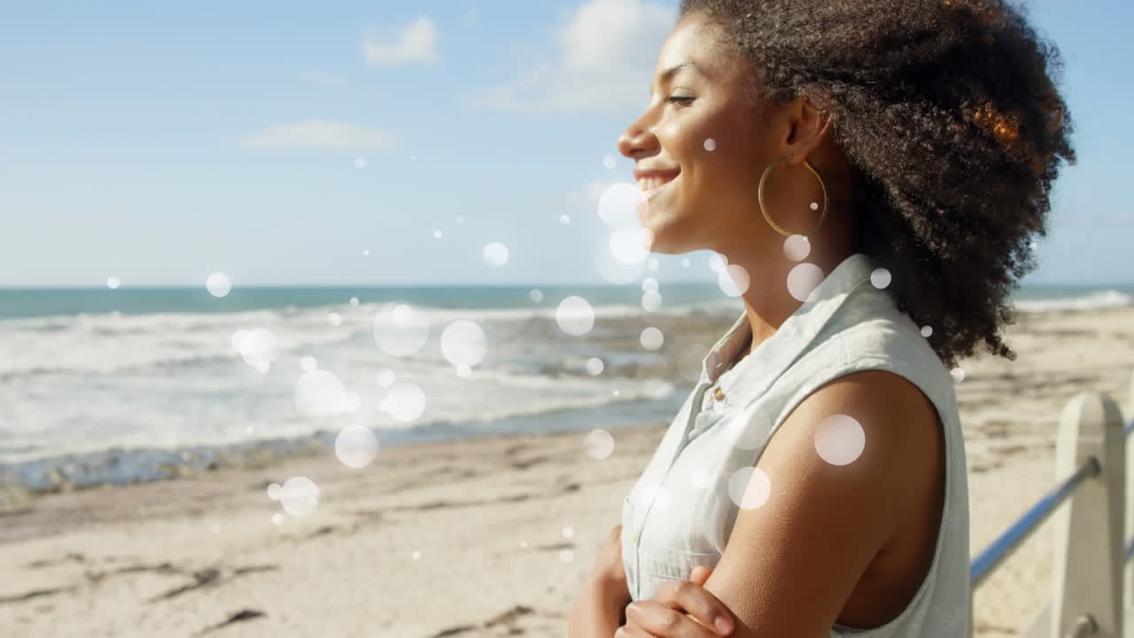 Digital animation of beautiful African-american woman, arms crossed, smiling and looking sea