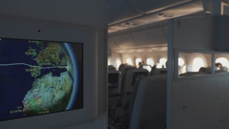 in flight screen showing travel time on airplane to destination on globe for international trip economy class