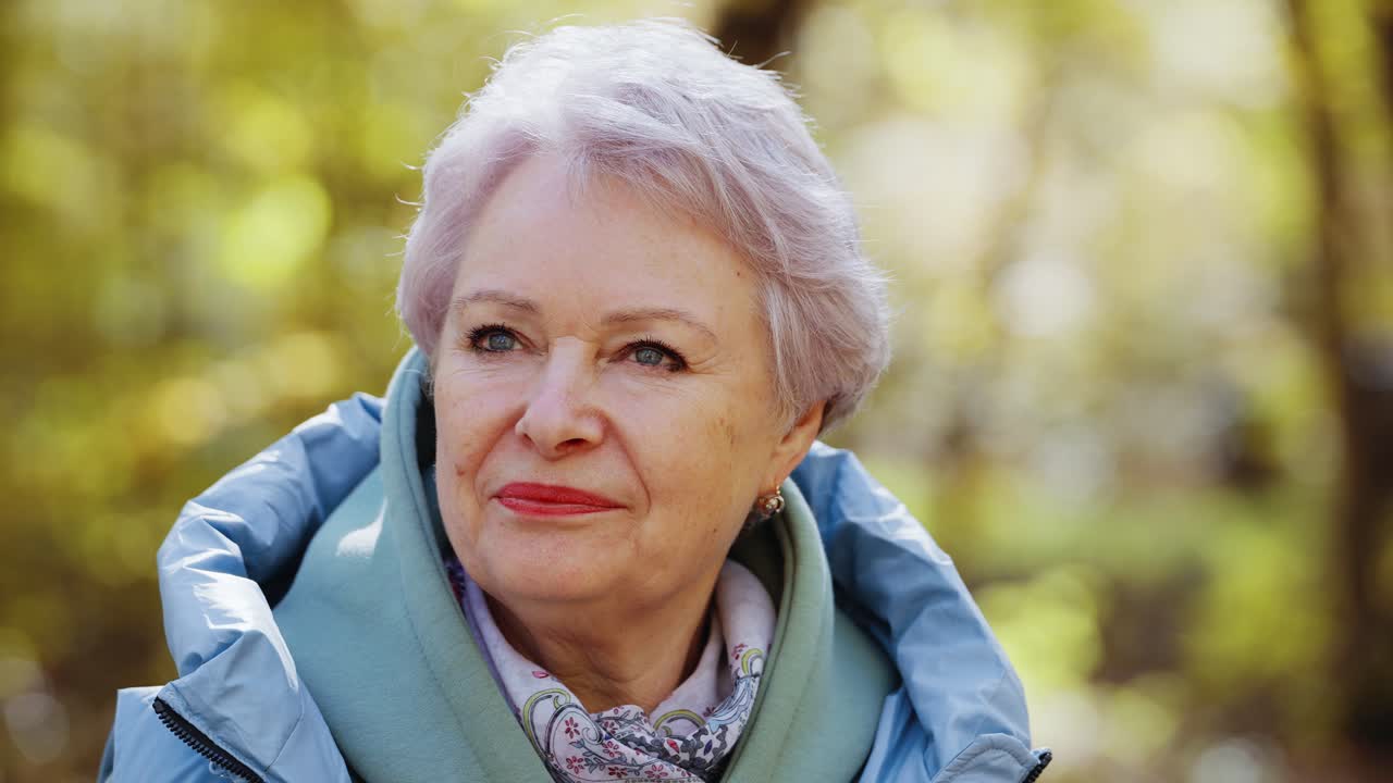 Close-up Portrait of a Serene Senior Woman in an Autumn Park