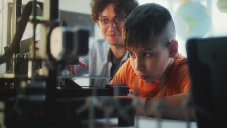 teacher and student working on 3d printer