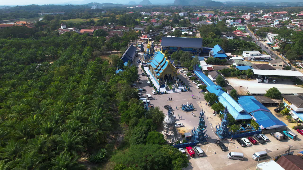 Drone approaching the Blue temple (Wat Rong Suea Ten), in Chiang Rai, Thailand