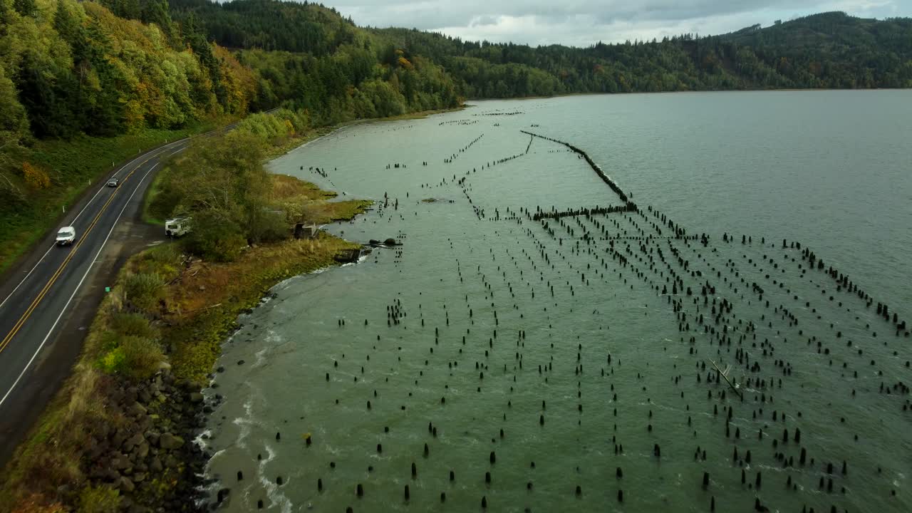 US, WA, Chinook, 2025-10-25 - Drone view of old dock pilings along the Columbia River just before a storm