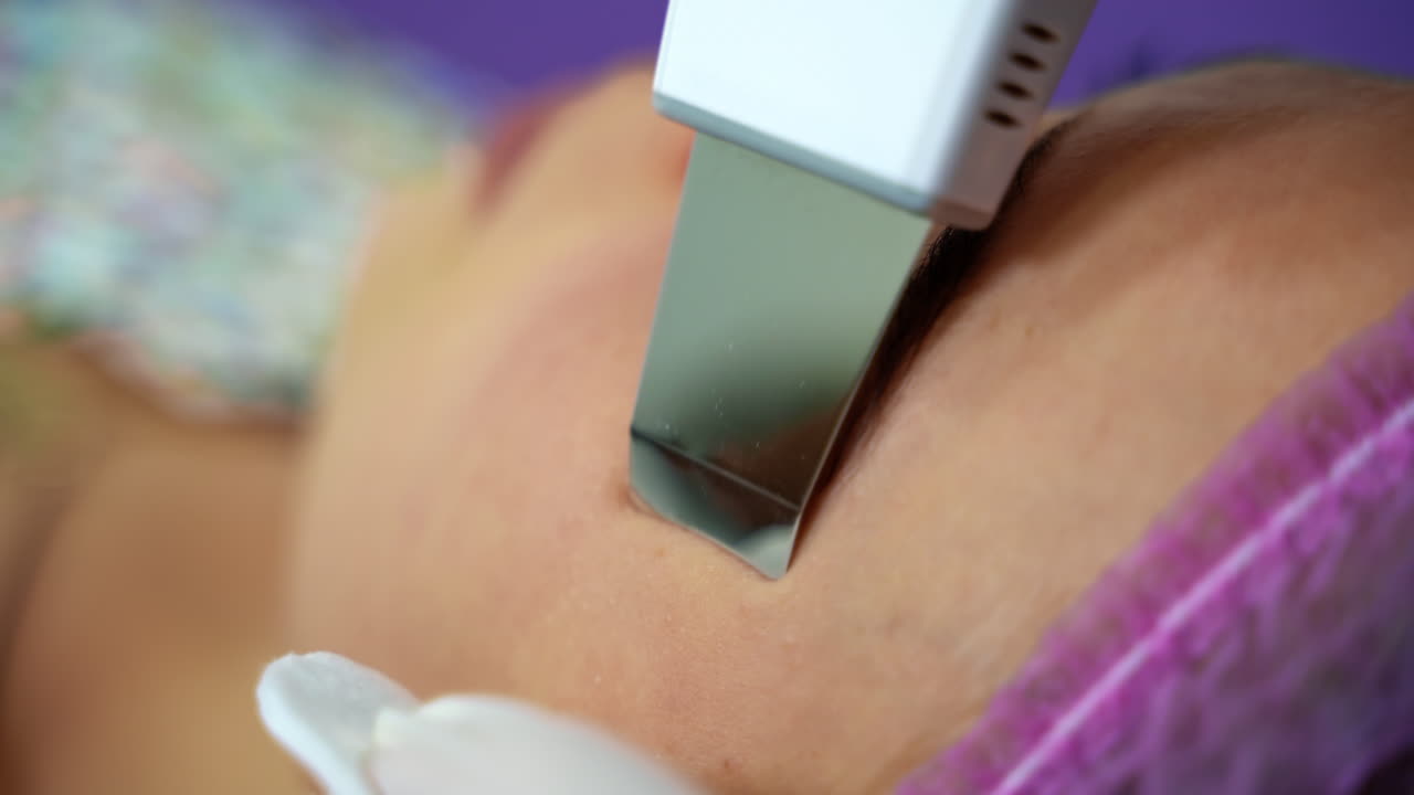 Close-up shot of cosmetician making cavitation facial peeling. Woman resting after hard working week.