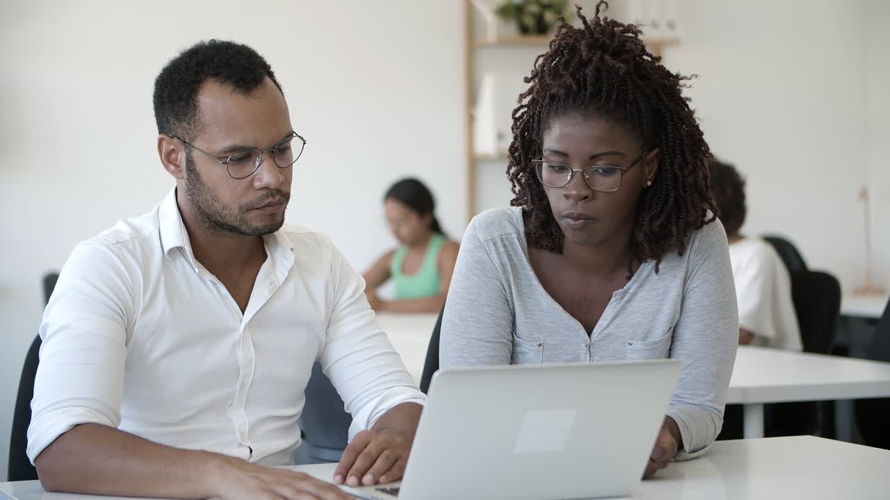 Confident African American man talking to colleague at office.