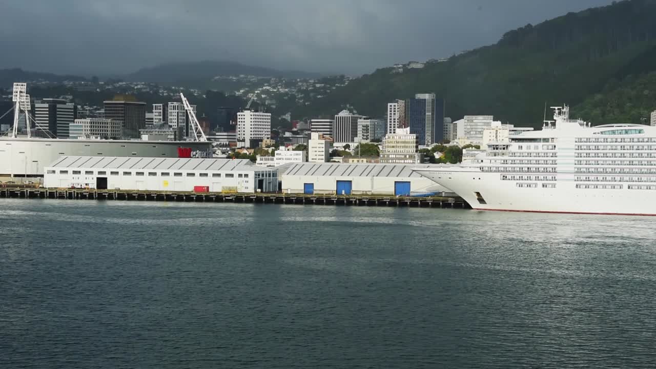 View from a ship leaving the port of Wellington. Ferry, Sky Stadium and terminals, Skyline of Wellington in the background.