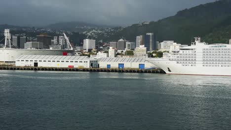 view from a ship leaving the port of wellington. ferry, sky stadium and terminals, skyline of wellington in the background.