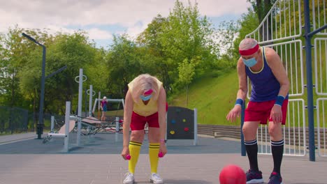 Active-senior-man-woman-playing-basketball-on-sports-playground-court-during-coronavirus-pandemic