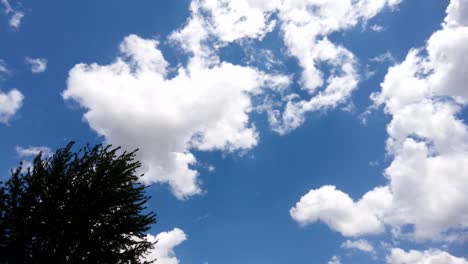 Beautiful-white-clouds-drift-by-in-a-bright-blue-sky,-timelapse