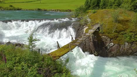 Suspension-bridge-over-the-mountain-river,-Norway.