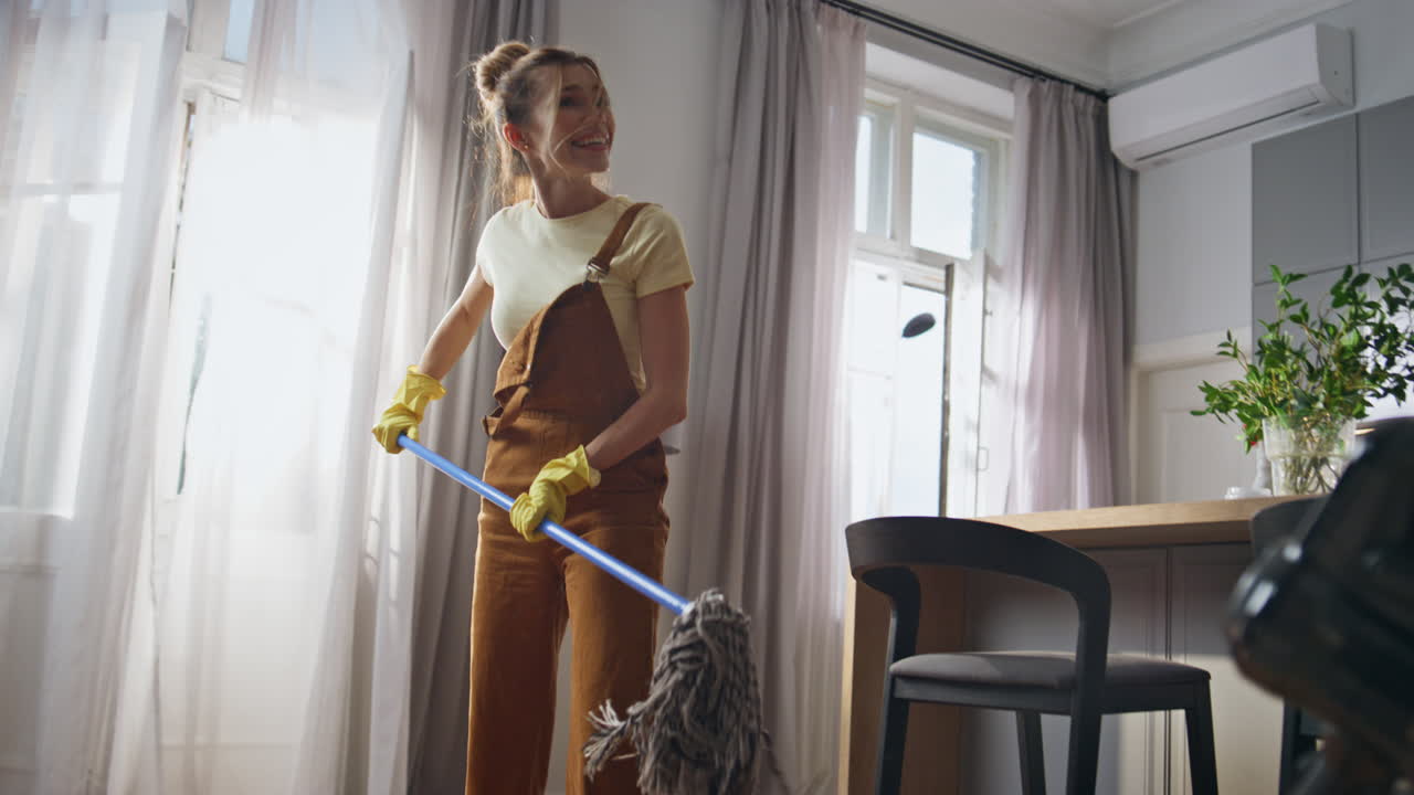 Cleaning pair having fun home kitchen. Happy couple laughing washing apartment